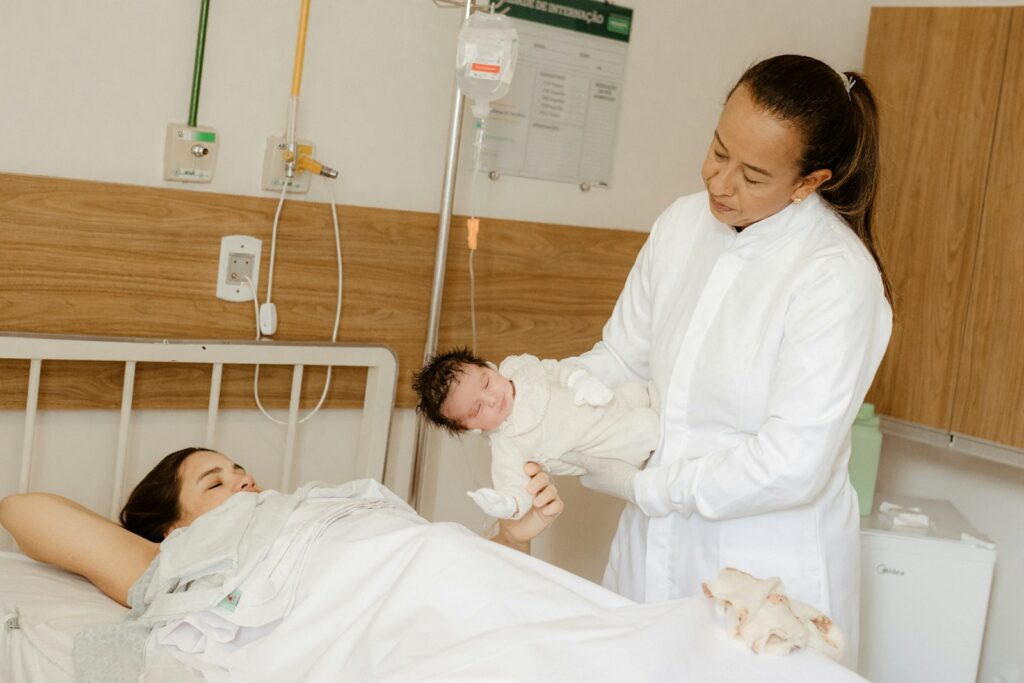 a woman holding a baby in a hospital bed