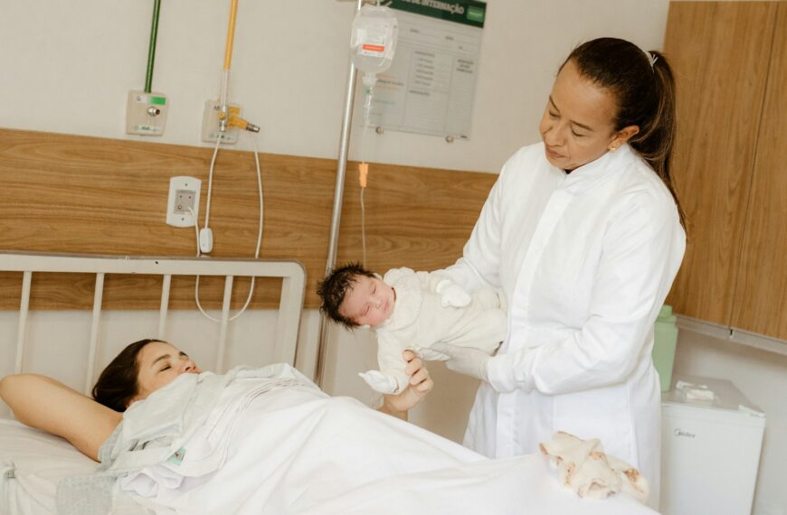 a woman holding a baby in a hospital bed