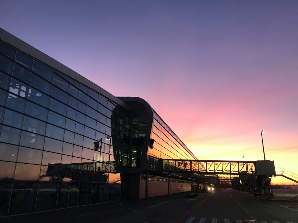 the sun is setting behind a glass building