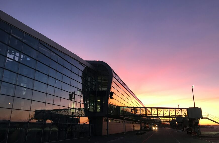 the sun is setting behind a glass building
