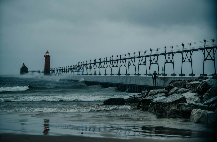 a light house sitting on top of a pier next to the ocean