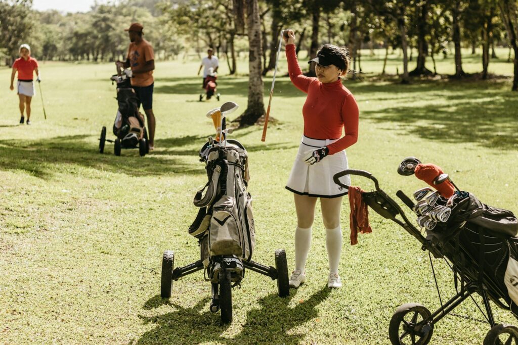 a woman in a red shirt and white skirt holding a golf club