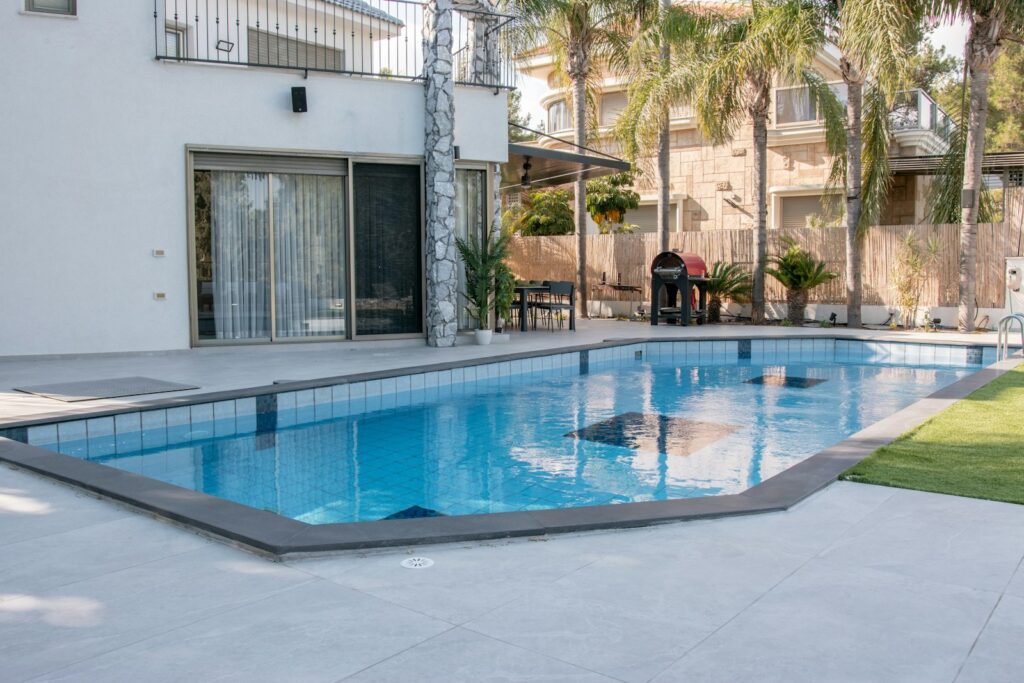 A modern house with a swimming pool and palm trees.