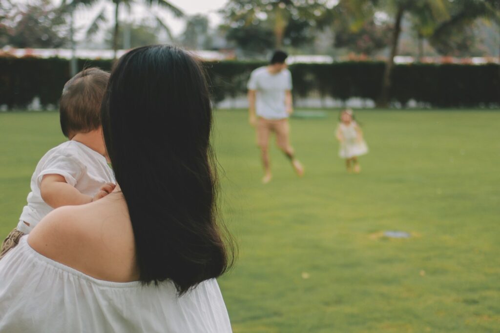 Family playing on a grassy field outdoors.