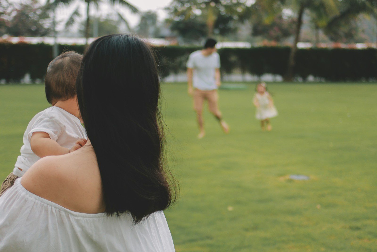 Family playing on a grassy field outdoors.