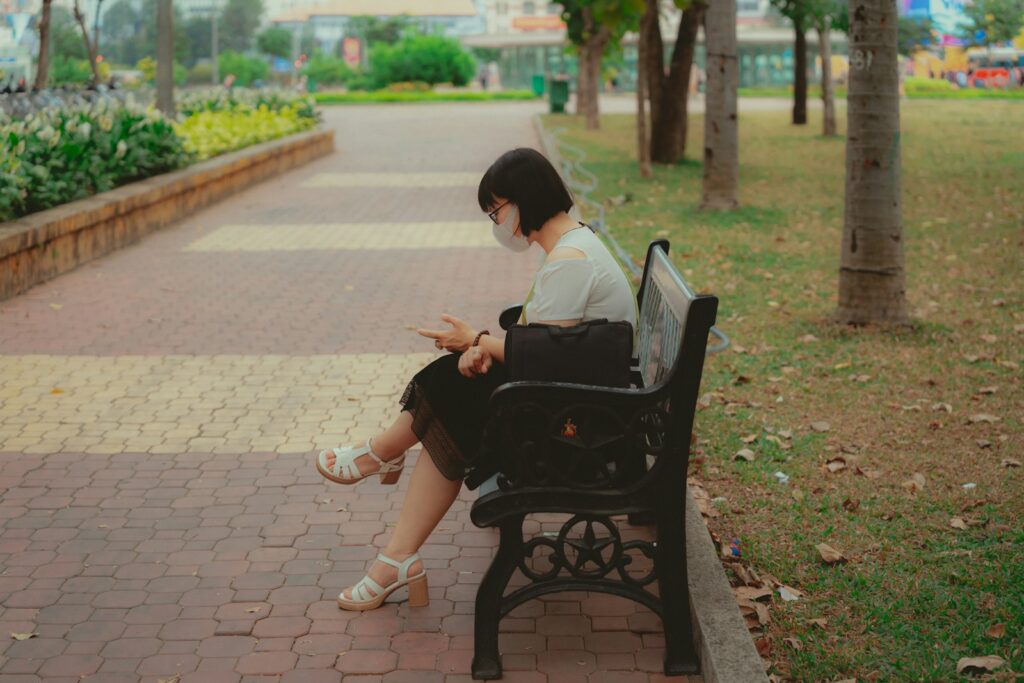 A woman sitting on a bench in a park