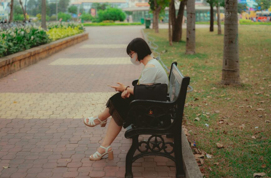 A woman sitting on a bench in a park