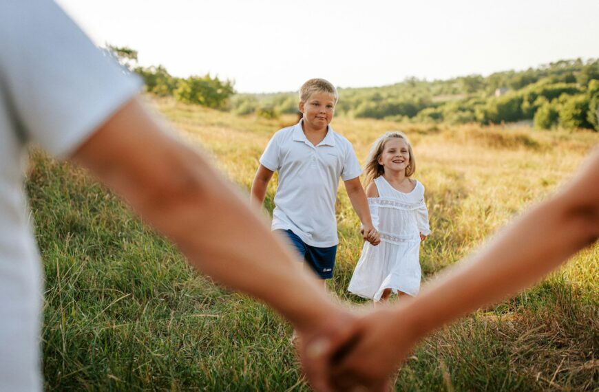 A couple of people holding hands in a field