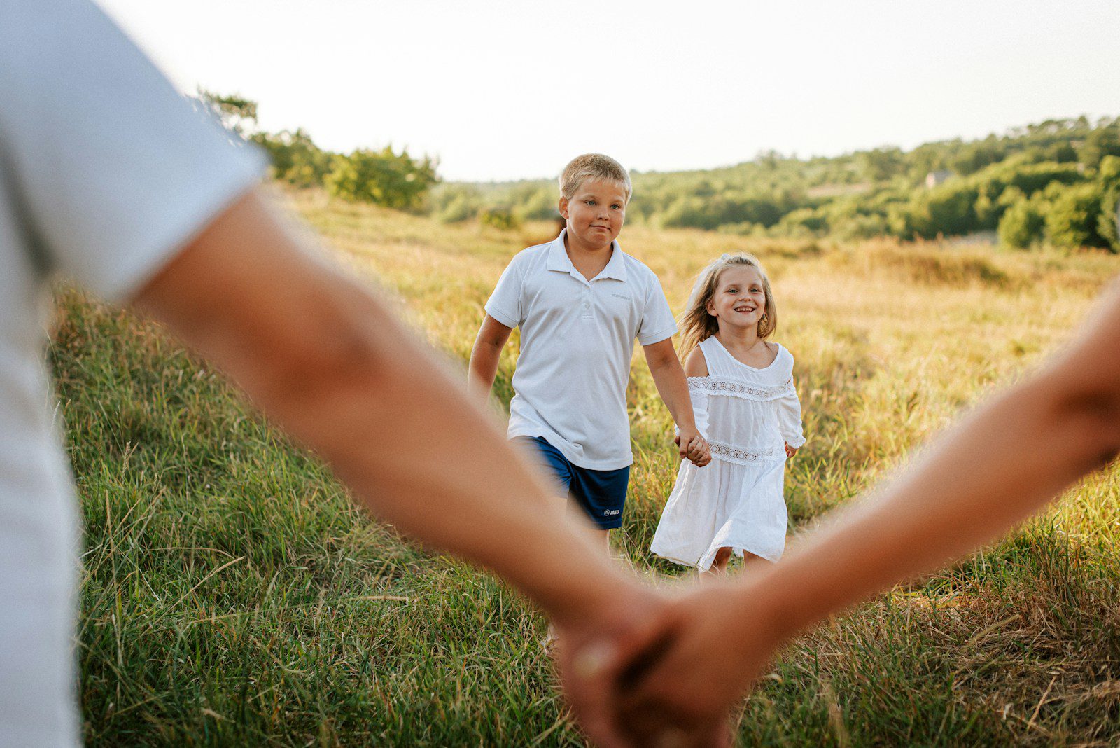 A couple of people holding hands in a field