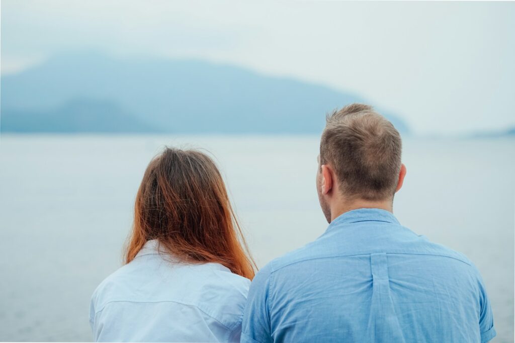 man in blue dress shirt beside woman in white shirt