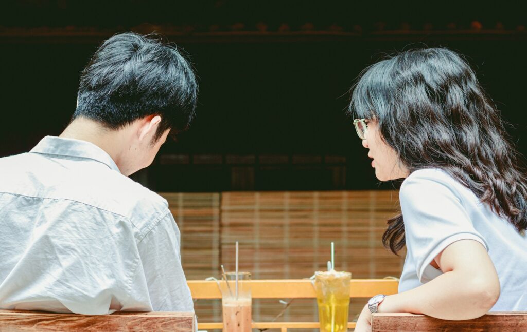 a man and woman sitting at a table with drinks