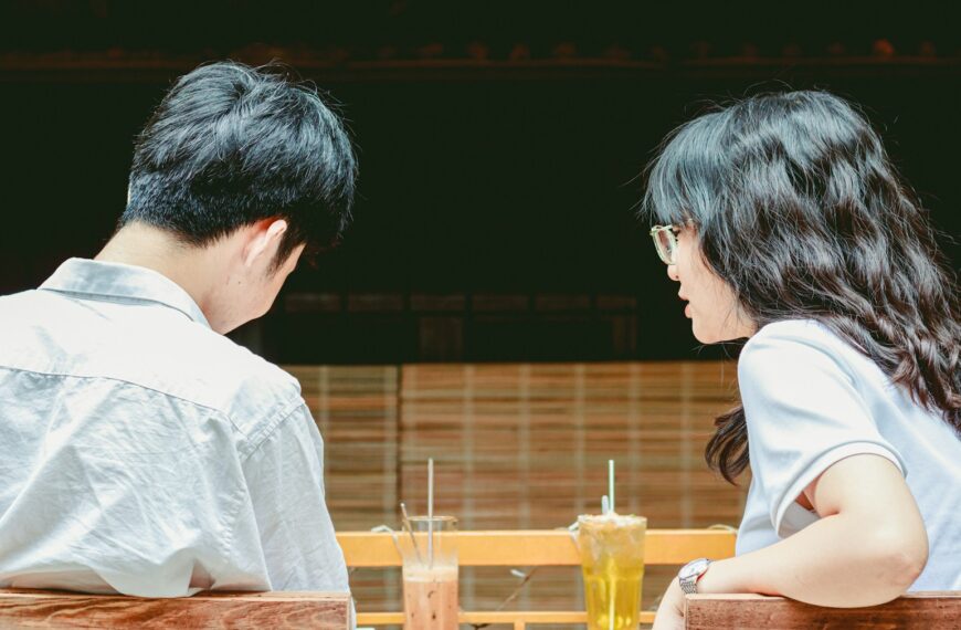 a man and woman sitting at a table with drinks