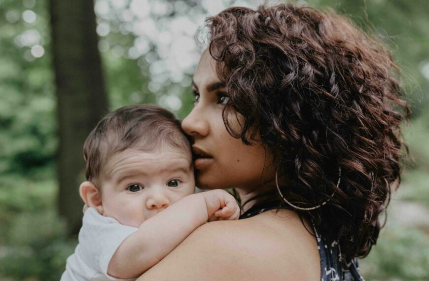 woman carrying baby during daytime