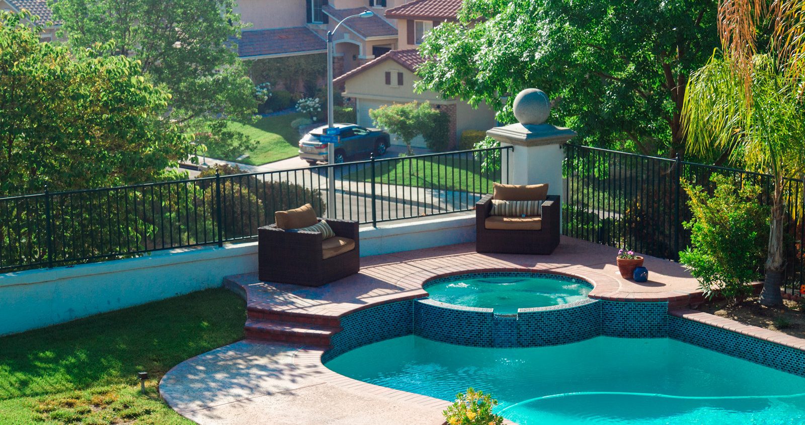 blue swimming pool near green trees during daytime
