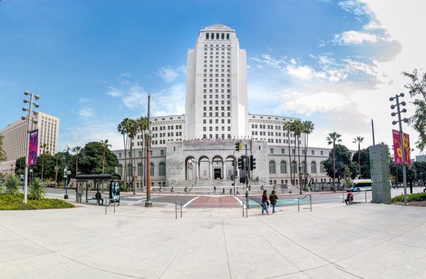 people walking on park near white concrete building during daytime