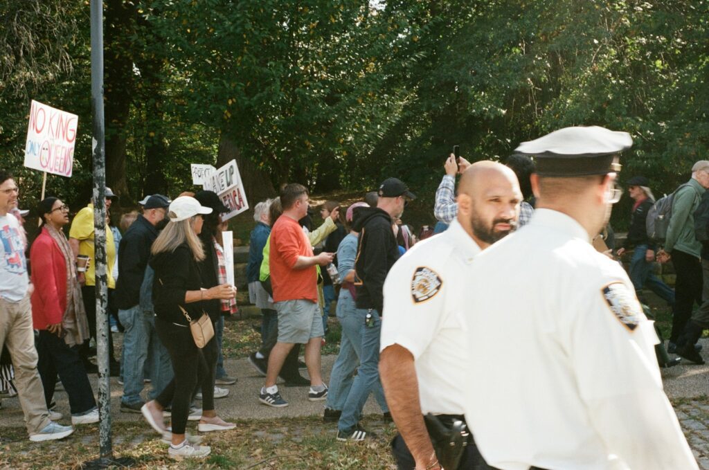 Police officers observe a crowd with signs.