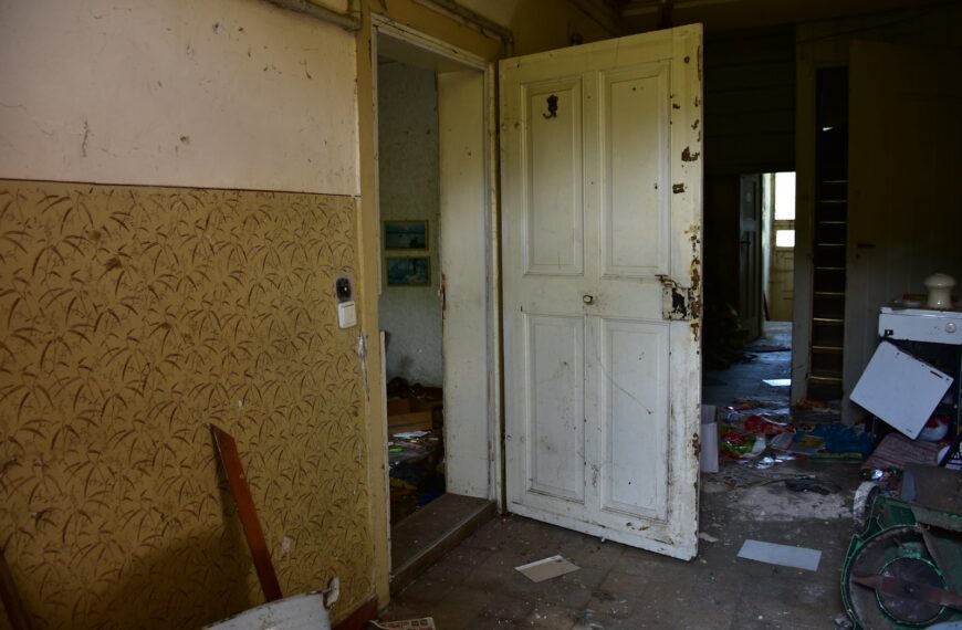 Abandoned room with open doors and debris