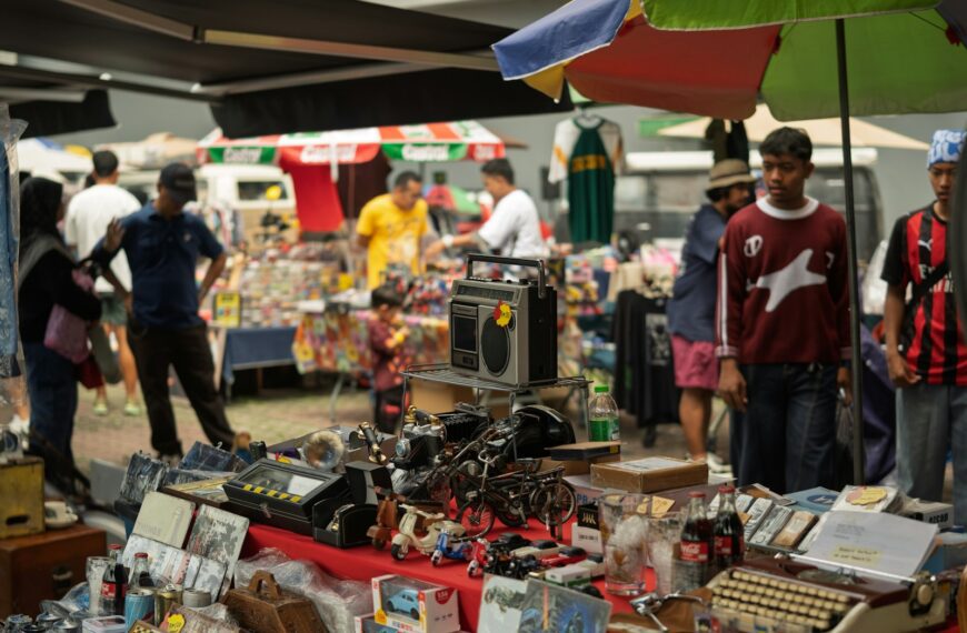 People browsing items at an outdoor market stall.