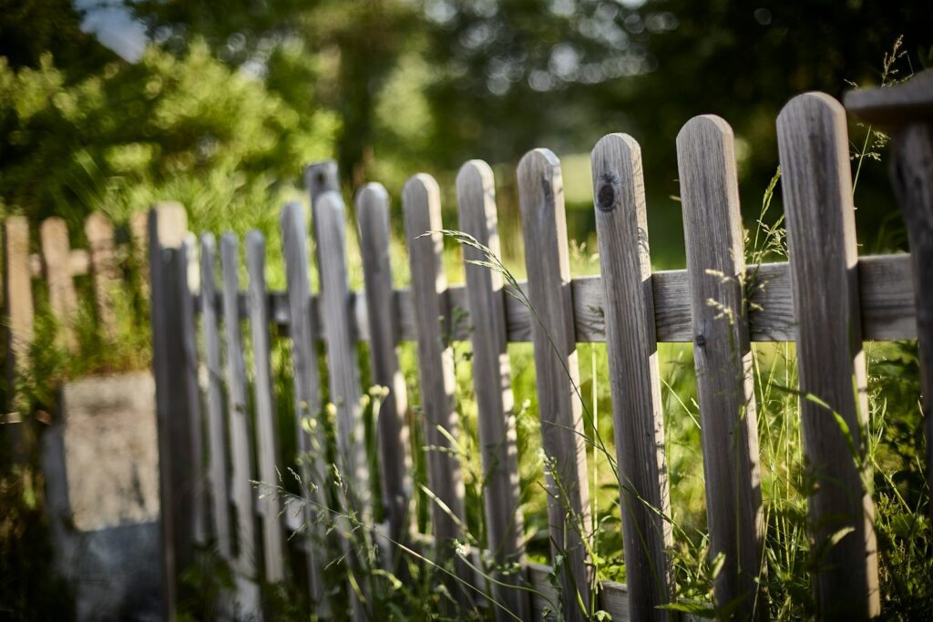 a close up of a wooden fence in the grass