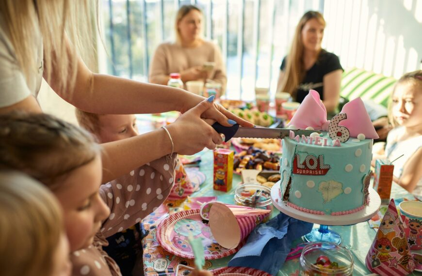 a group of people sitting around a table with a cake