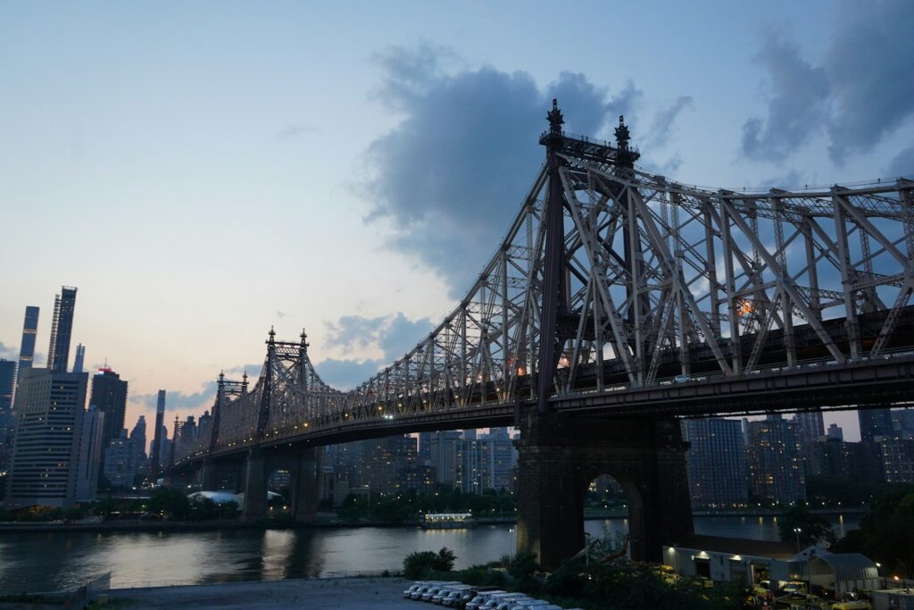 gray bridge over body of water under cloudy sky during daytime