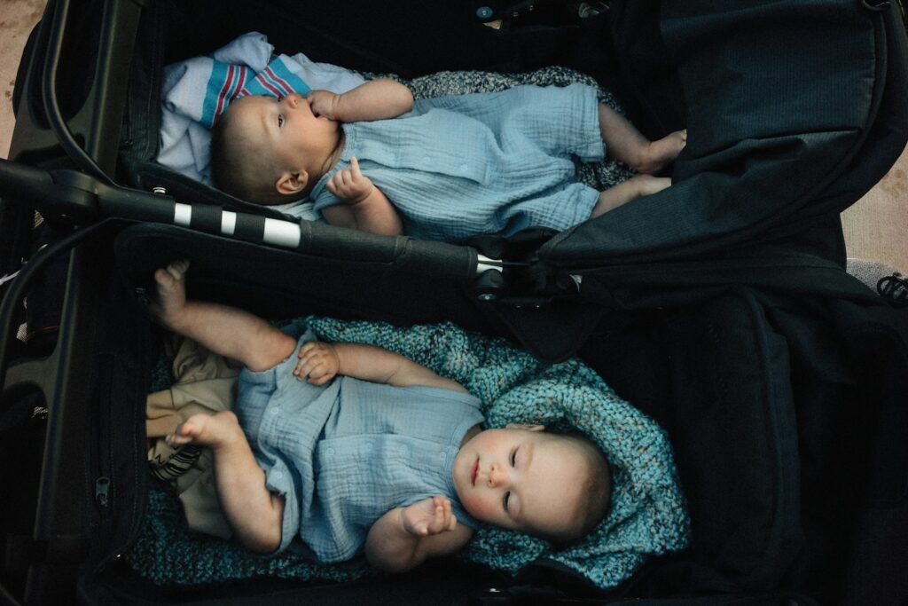 Twins resting comfortably in their stroller.