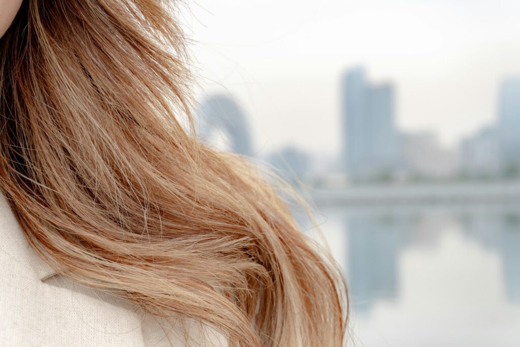 Long hair against a blurred city backdrop.