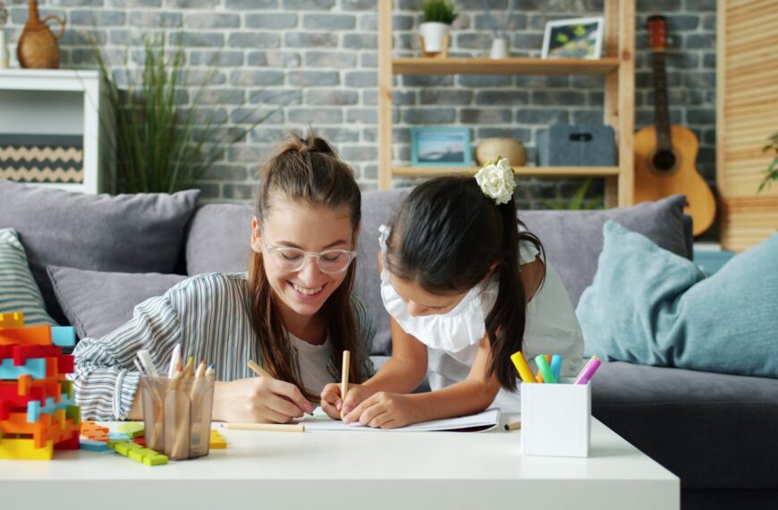 Woman and child drawing together on a couch.