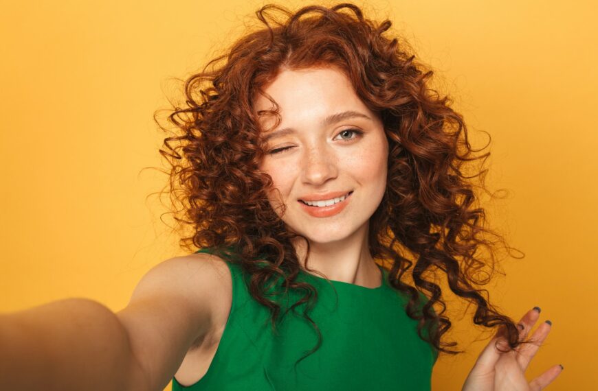 a woman with red curly hair and a green dress