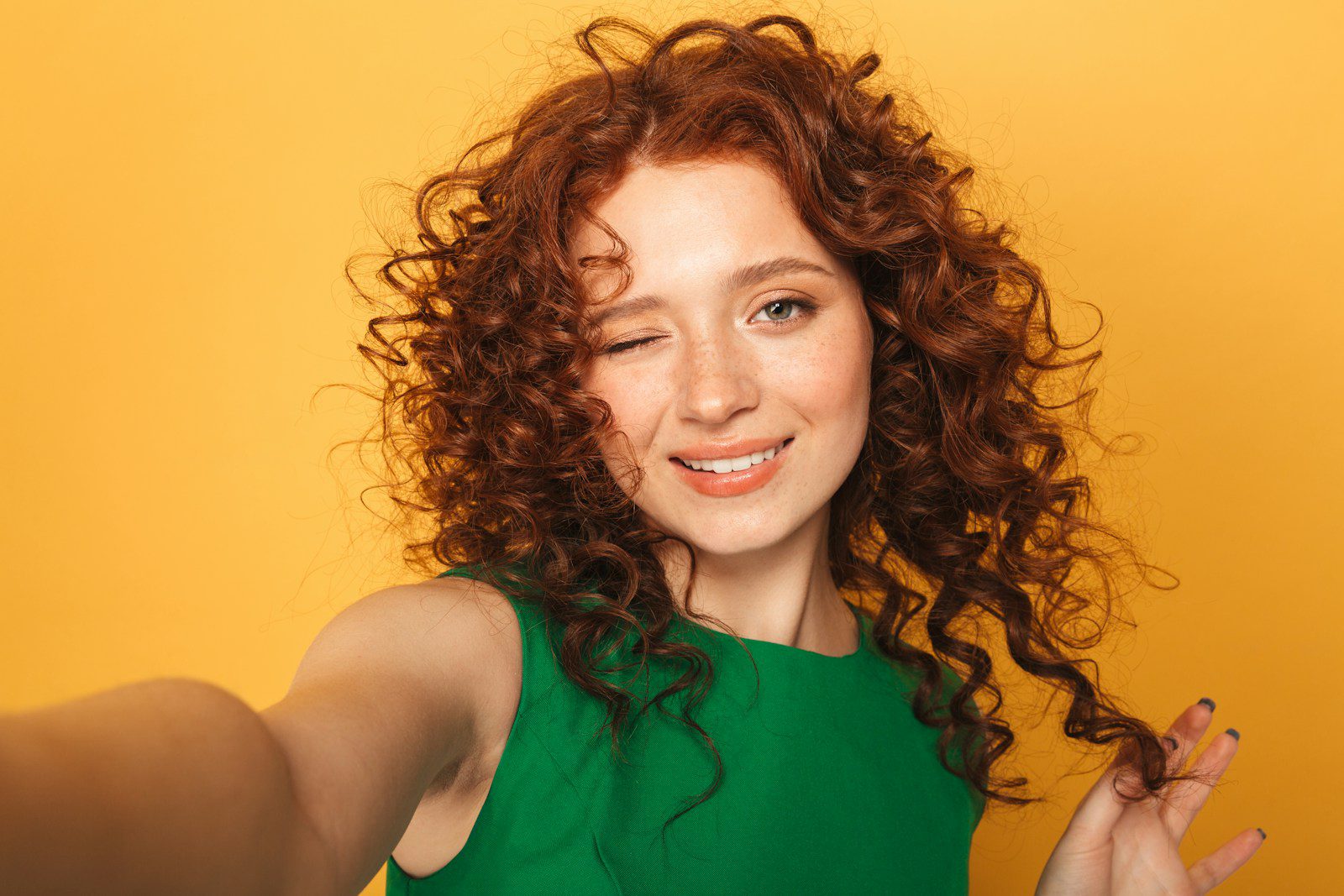 a woman with red curly hair and a green dress