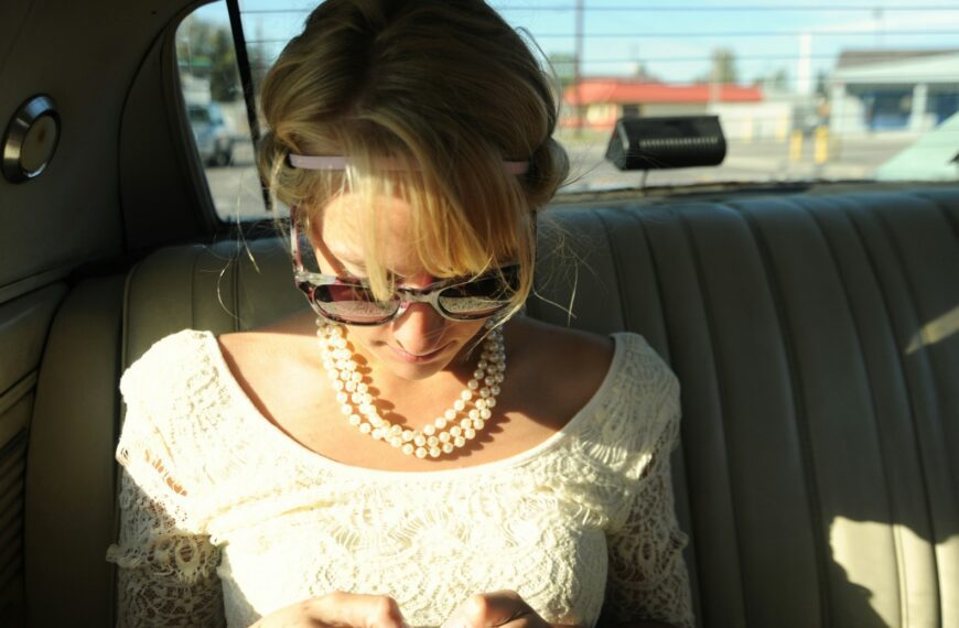 woman wearing white scoop-neck top inside vehicle