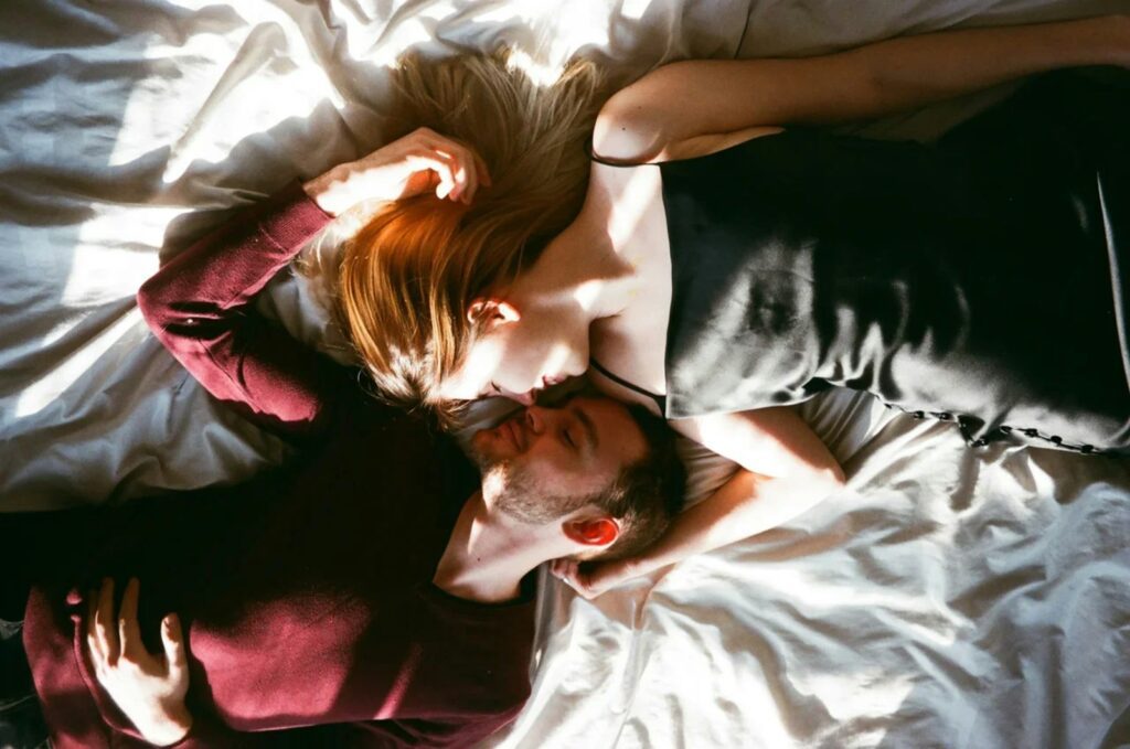 a man and a woman laying on a bed