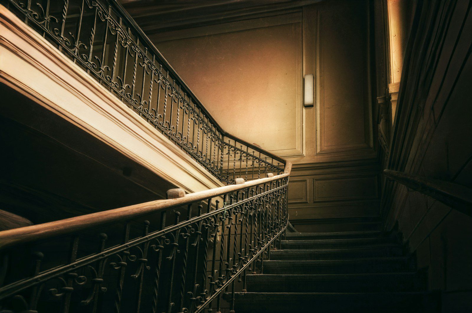 A dark, ornate staircase with a vintage feel