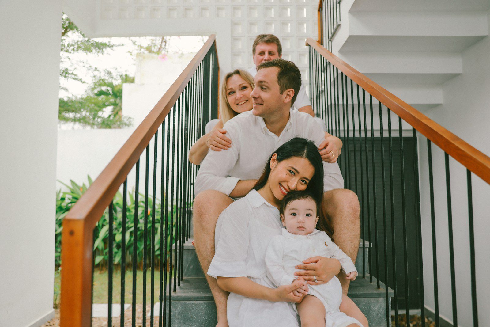 Family sitting on stairs, dressed in white