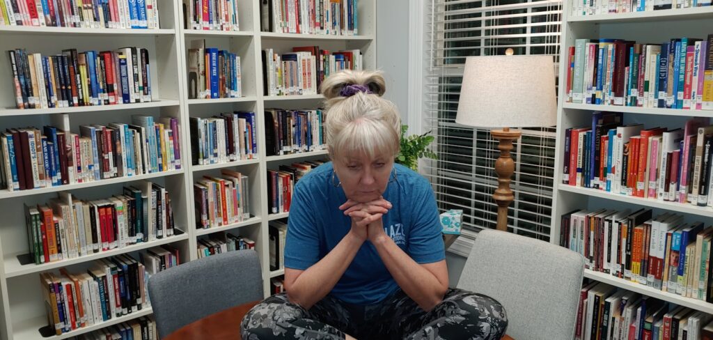 a woman sitting on a table in front of a bookshelf