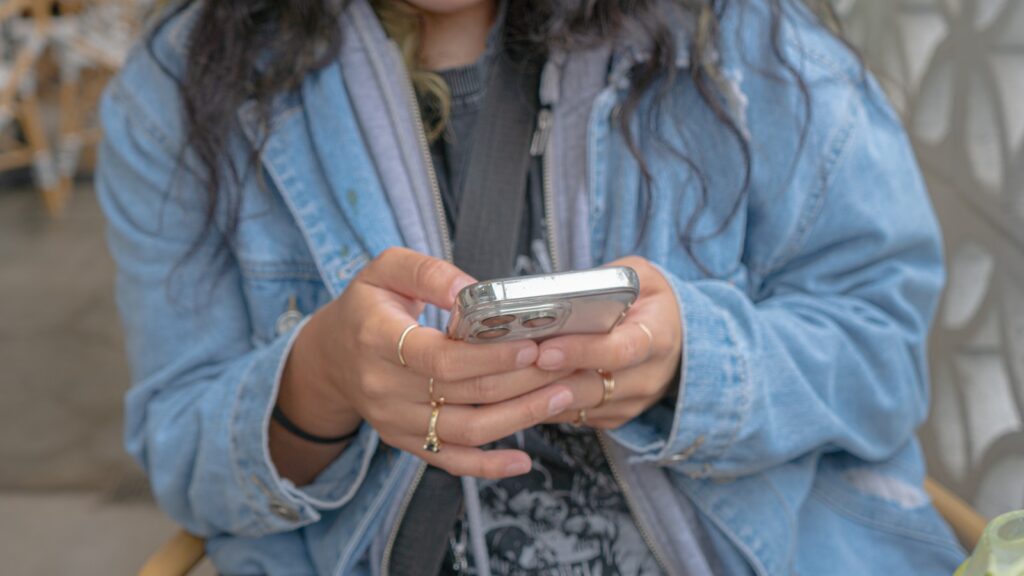 A woman sitting in a chair looking at her cell phone