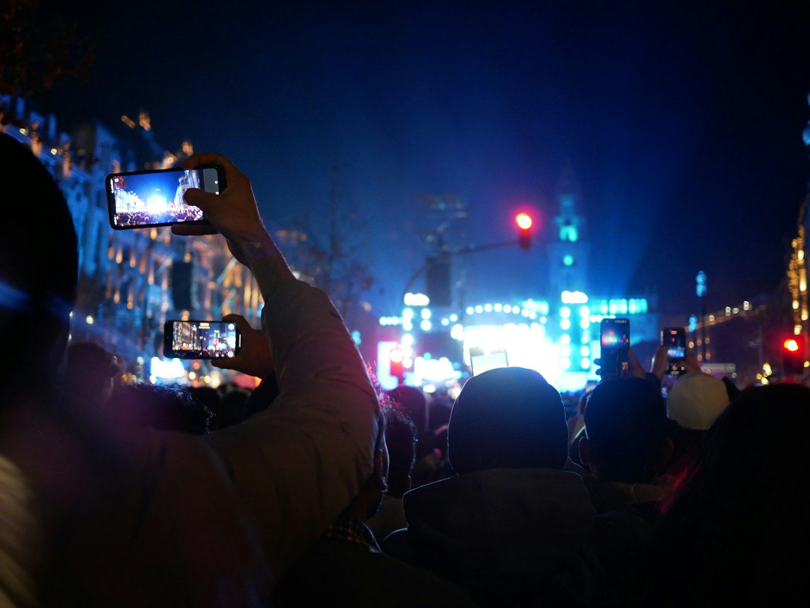 A crowd of people standing around a street at night