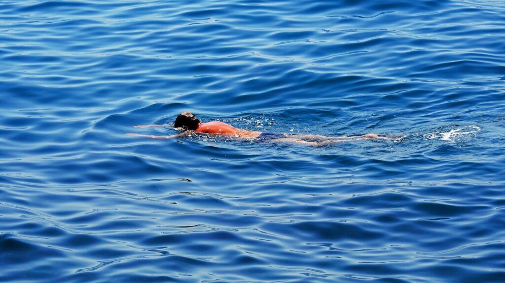 Person swimming in the blue ocean water