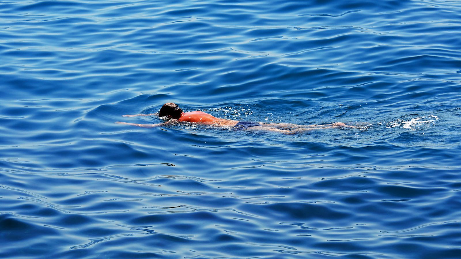 Person swimming in the blue ocean water