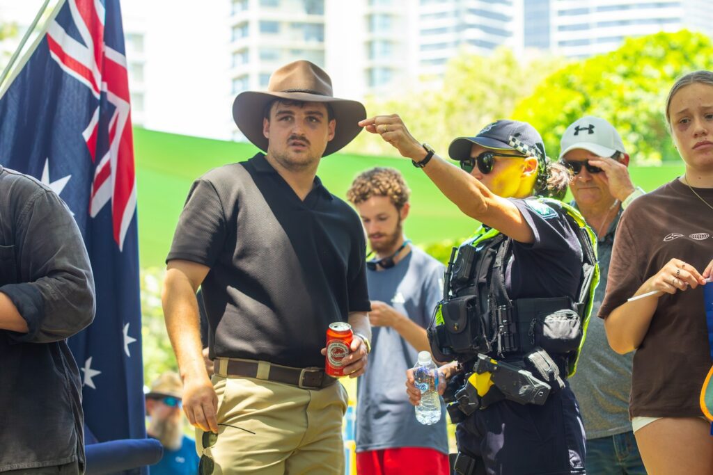 Man in hat receives something from police officer