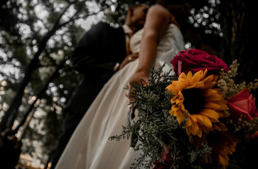 woman in white wedding dress kissing man in black suit