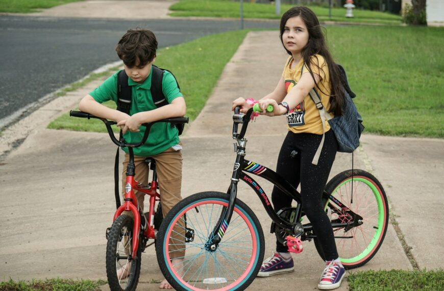woman in green shirt riding red bicycle beside woman in green shirt during daytime