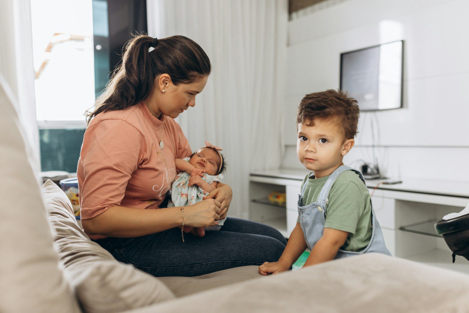 a woman sitting on a couch holding a baby