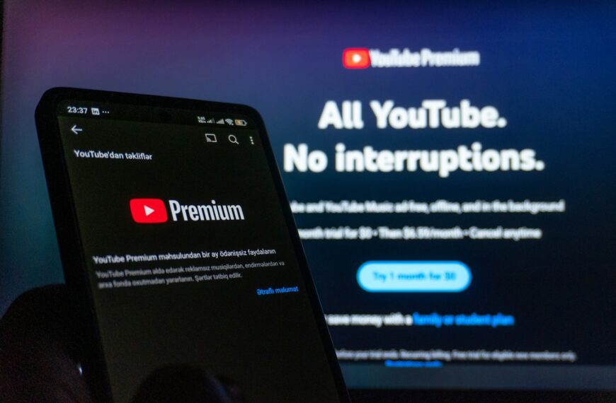 Smartphone displaying youtube premium next to TV screen.