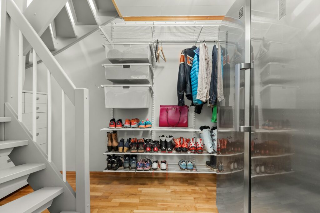 A walk in closet with a lot of shoes