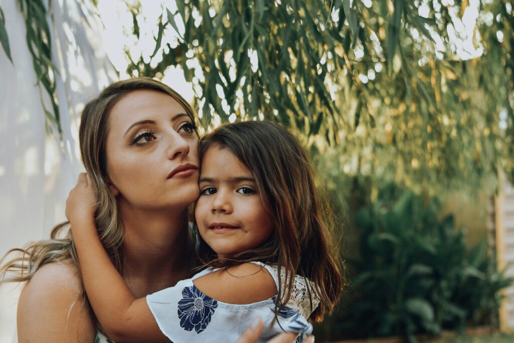selective focus photo of woman carrying a girl