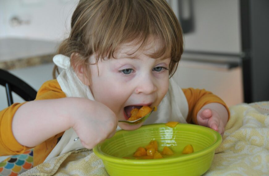 child in white shirt eating
