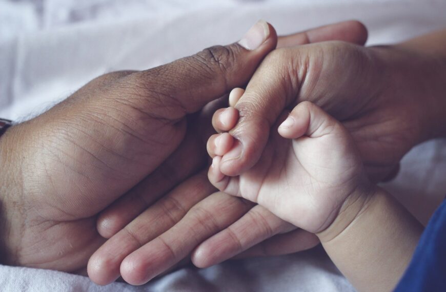 persons hand with white nail polish