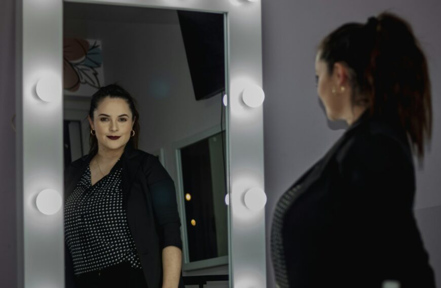 a woman standing in front of a mirror