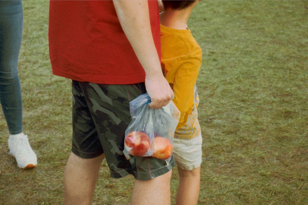 woman in red tank top holding plastic bag